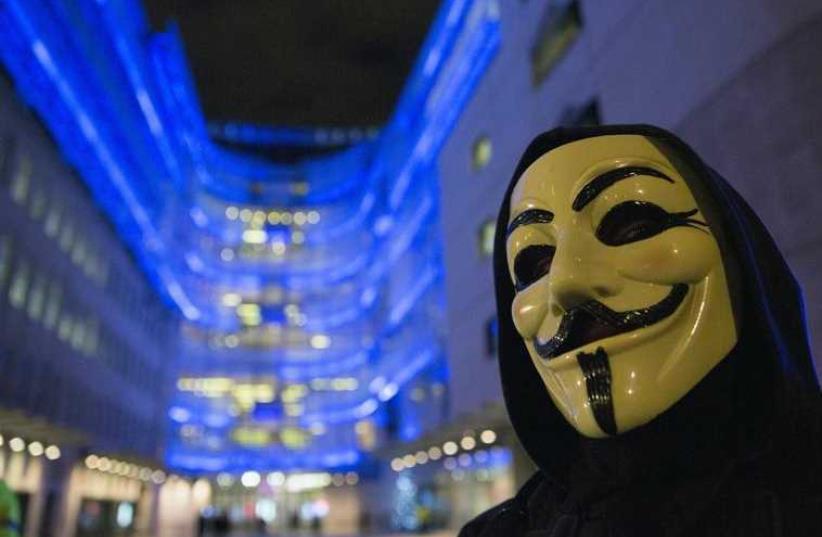 A supporter of the activist group Anonymous wears a mask during a protest against the BBC outside their studios in central London (photo credit: REUTERS)