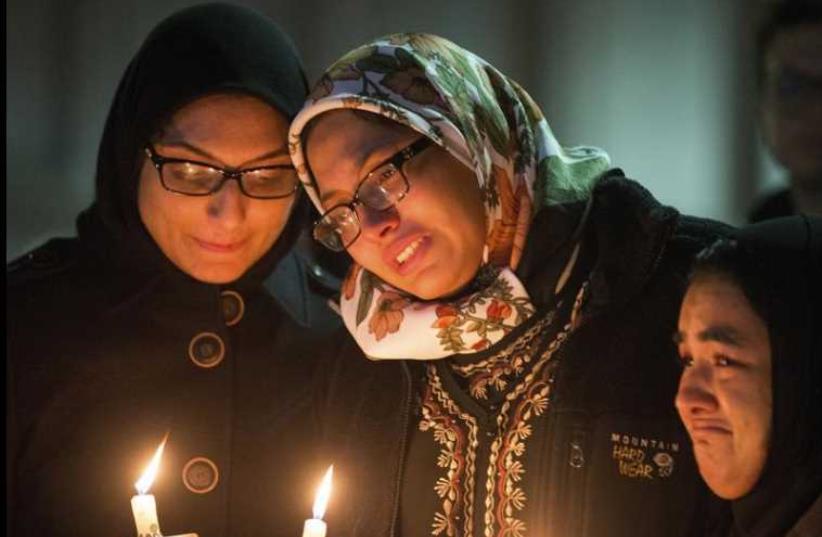 Students with lit candles attend a vigil on the campus of the University of North Carolina, for Deah Shaddy Barakat, his wife Yusor Mohammad and Yusor's sister Razan Mohammad Abu-Salha who were killed in Chapel Hill, North Carolina February 11, 2015 (photo credit: REUTERS)