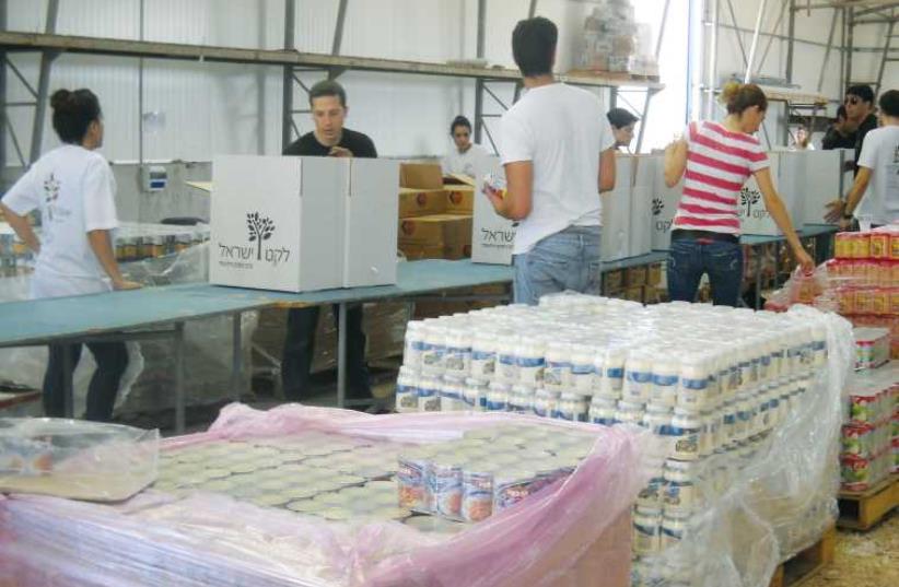 Volunteers at Leket Israel, The National Food Bank, package food for needy families. (photo credit: Courtesy)