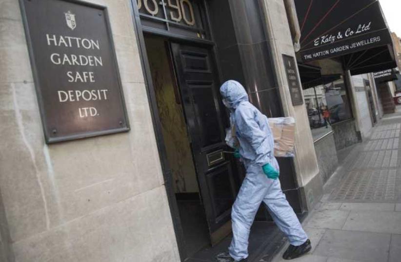 A police forensic officer enters the targeted building in central London’s diamond district (photo credit: REUTERS)