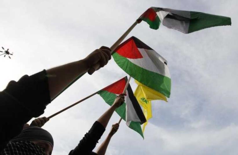 Palestinian and Hezbollah flags (photo credit: REUTERS)
