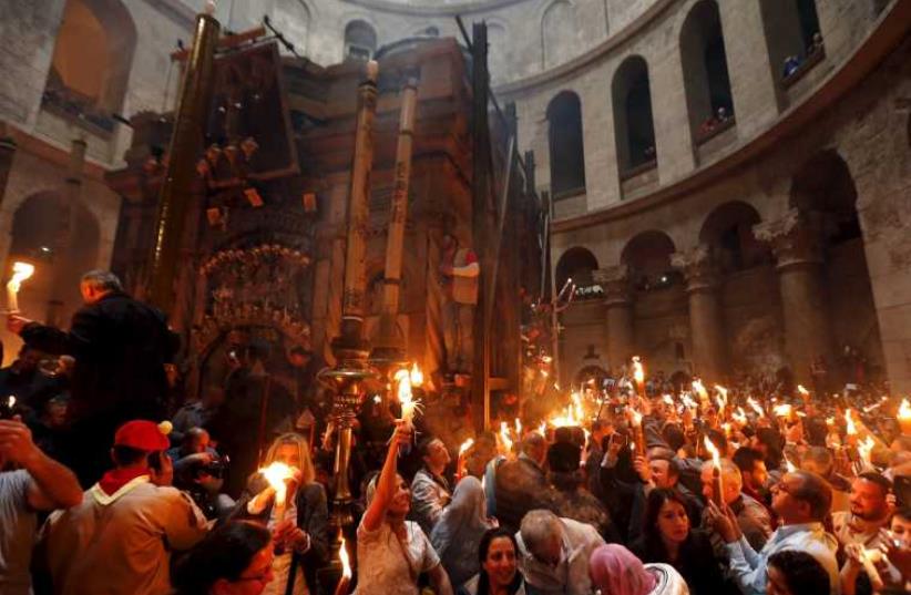 Worshippers hold candles as they take part in the Christian Orthodox Holy Fire ceremony at the Church of the Holy Sepulchre in Jerusalem (photo credit: REUTERS)