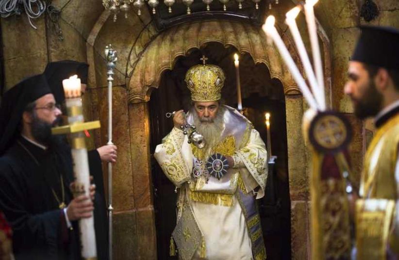 Greek Orthodox Patriarch of Jerusalem Metropolitan Theophilos (C) takes part in the Easter Sunday mass procession inside the Church of the Holy Sepulchre in Jerusalem's old city (photo credit: REUTERS)