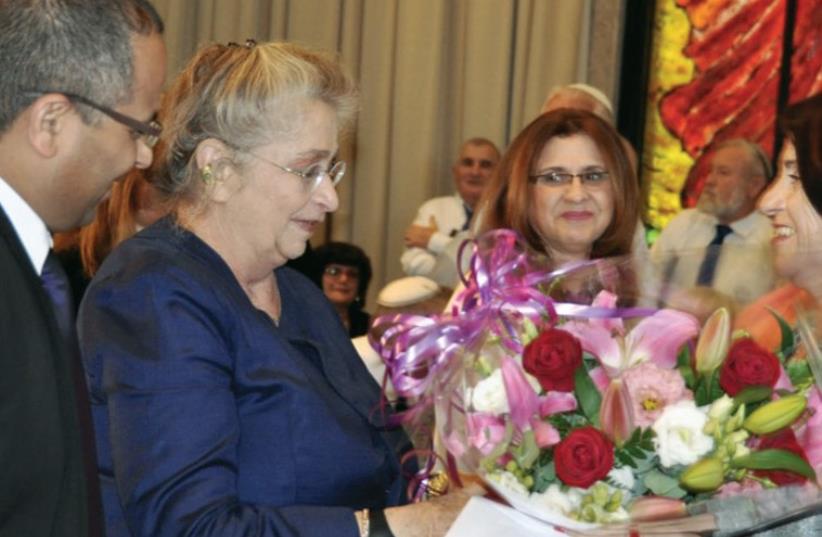 Nechama Rivlin (center) accepts a bouquet from author Dina Kit (photo credit: PRESIDENTIAL SPOKESPERSON OFFICE)