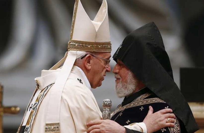 Pope Francis (L) embraces Catholicos of All Armenians Karekin II during a mass on the 100th anniversary of the Armenian mass killings, in St. Peter's Basilica at the Vatican  (photo credit: REUTERS)