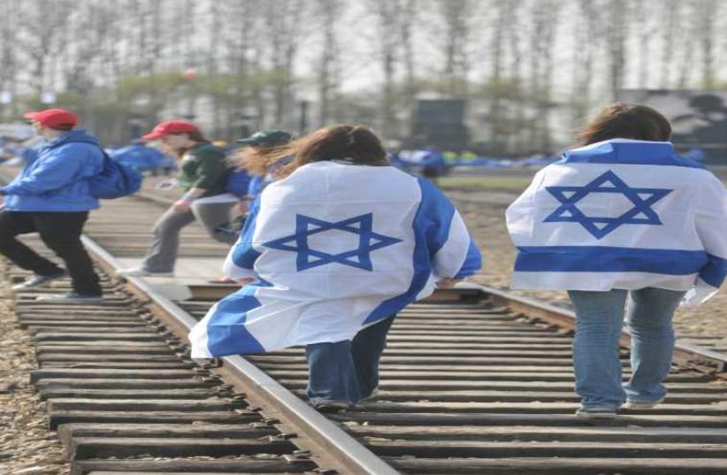 Teens march along the railway tracks leading to Auschwitz. (photo credit: YOSSI ZELIGER)