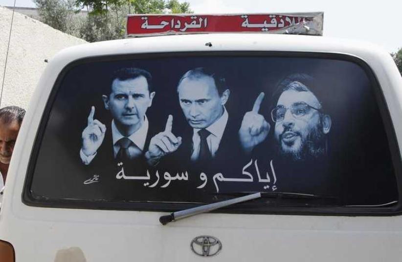 A poster showing Syrian President Bashar Assad (L), Russian President Vladimir Putin (C) and Lebanese Hezbollah leader Hassan Nasrallah is seen on a micro bus near Latakia (photo credit: REUTERS)