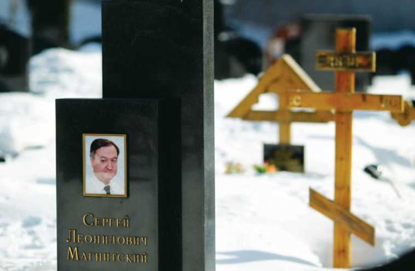 A photo of lawyer Sergei Magnitsky on his grave in the Preobrazhensky cemetery in Moscow. (photo credit: REUTERS)