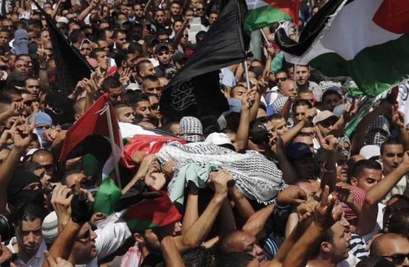 Palestinians carry the body of 16-year-old Muhammad Abu Khdeir during his funeral in Shuafat (photo credit: REUTERS)