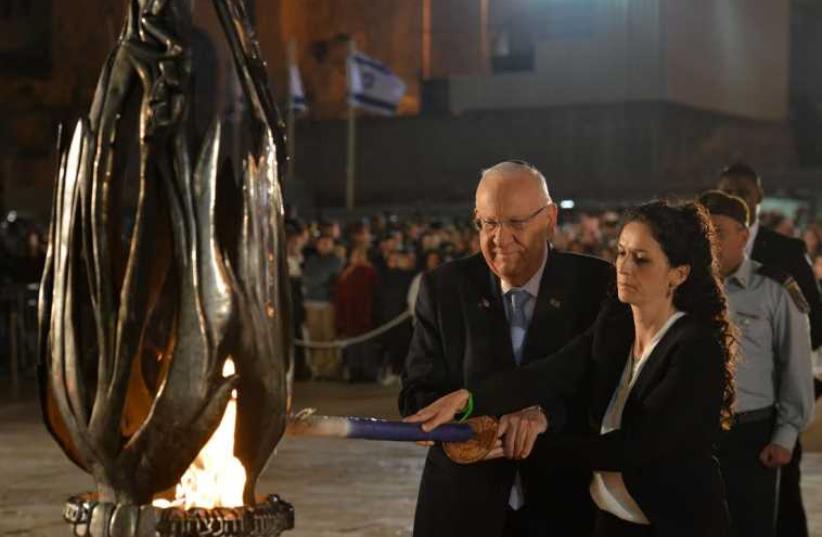 President Rivlin kindling the memorial flame together with Mrs. Moriah Ashkenazi, widow of First Sergeant Yair Ashkenazi, who fell in battle during Operation Protective Edge (photo credit: KOBI GIDEON/GPO)