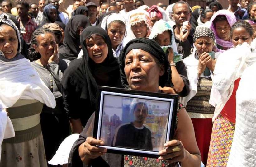 A woman mourns with the framed picture of a man said to be among the 30 Ethiopian victims killed by members of the militant Islamic State in Libya, in the capital Addis Ababa, (photo credit: REUTERS)