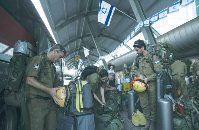 IDF SOLDIERS, members of an aid delegation, prepare their equipment as they wait for a flight to Nepal at Ben-Gurion Airport (photo credit: REUTERS)