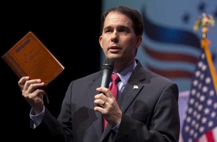 Governor of Wisconsin and potential Republican U.S. Presidential candidate Scott Walker refers to the book "Jesus Calling" at the Iowa Faith and Freedom Coalition's forum in Waukee, Iowa (photo credit: REUTERS)