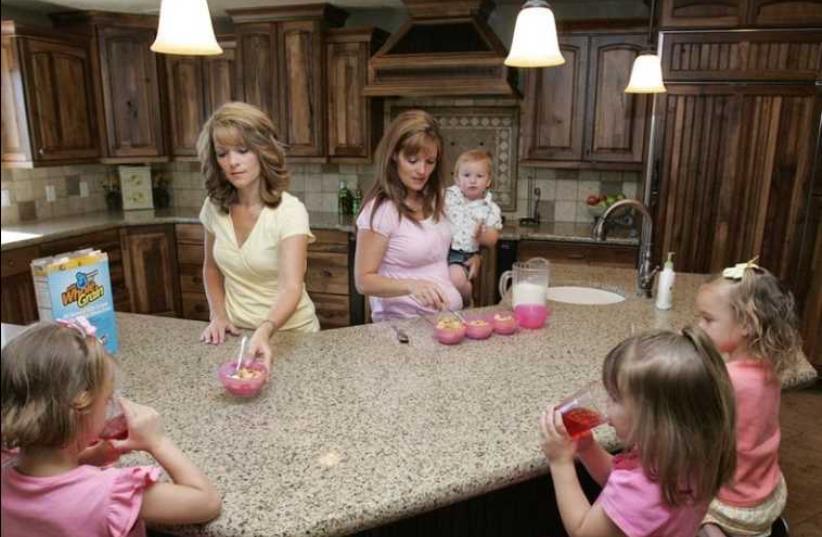 Sister-wives Valerie (L) and Vicki serve breakfast to their children in their polygamous house in Herriman, Utah (photo credit: REUTERS)