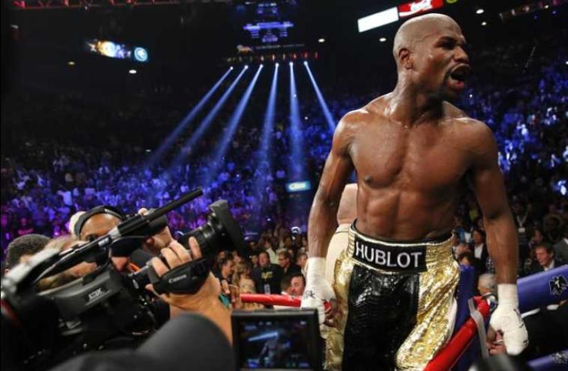 Floyd Mayweather Jr. of the U.S. yells out to the crowd after defeating Manny Pacquiao of the Philippines in their title fight in Las Vegas, Nevada, May 2, 2015.  (photo credit: REUTERS)