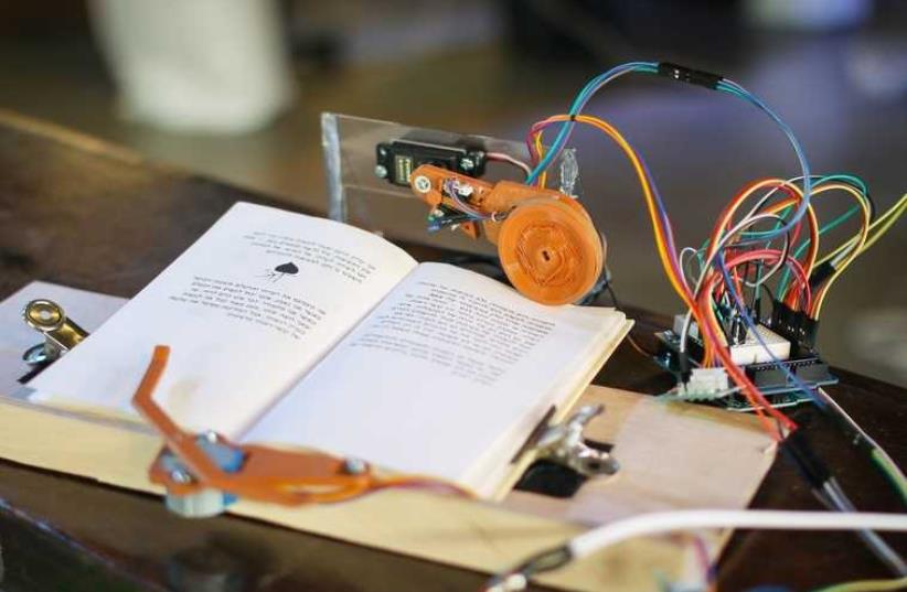 This system developed at a Tikkun Olam Makers (TOM) "make-a-thon" allows people who are paralyzed from the neck down to turn pages in a book. (photo credit: JNS.ORG)