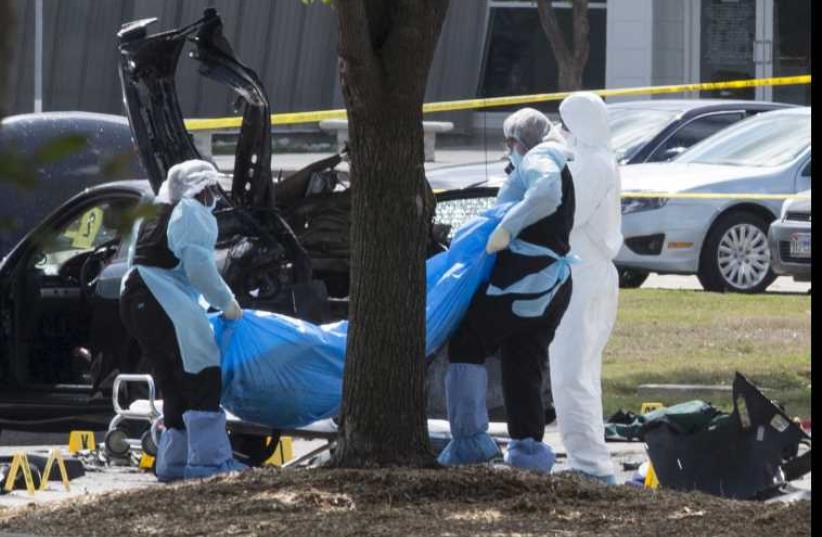 The bodies of two gunmen are removed from behind a car during an investigation by the FBI and local police in Garland, Texas May 4, 2015.  (photo credit: REUTERS)