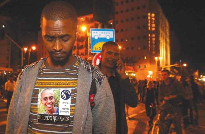 A man wears a sign that says ‘I am also Yosef Salamsa,’ an Ethiopian Israeli believed to have killed himself after alleged abuse by police. (photo credit: MARC ISRAEL SELLEM/THE JERUSALEM POST)