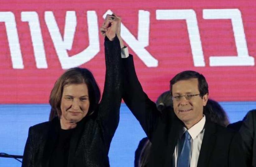 Isaac Herzog (R) and Tzipi Livni, co-leaders of Zionist Union, raise their arms at party headquarters in Tel Aviv (photo credit: REUTERS)
