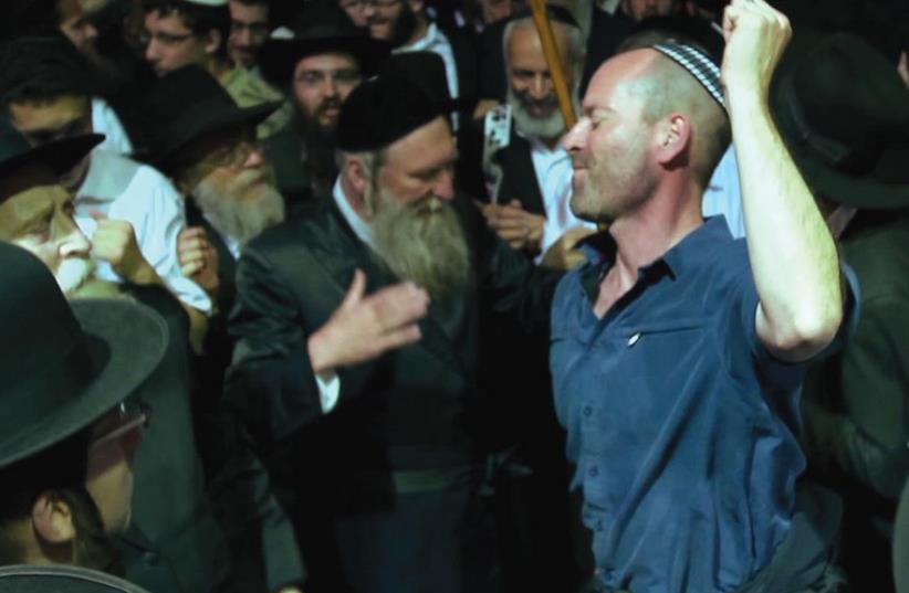 US FILMMAKER Steve Bram (right) dances with Orthodox Jewish men during a visit to Israel, as seen in ‘Kabbalah Me’  (photo credit: Courtesy)