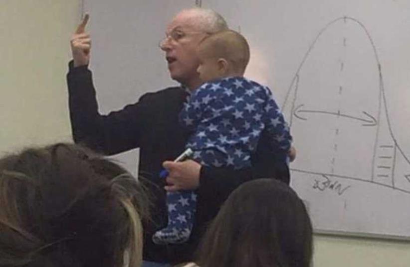Hebrew University Professor Sydney Engelberg holding a student’s baby while lecturing‏ (photo credit: FACEBOOK)