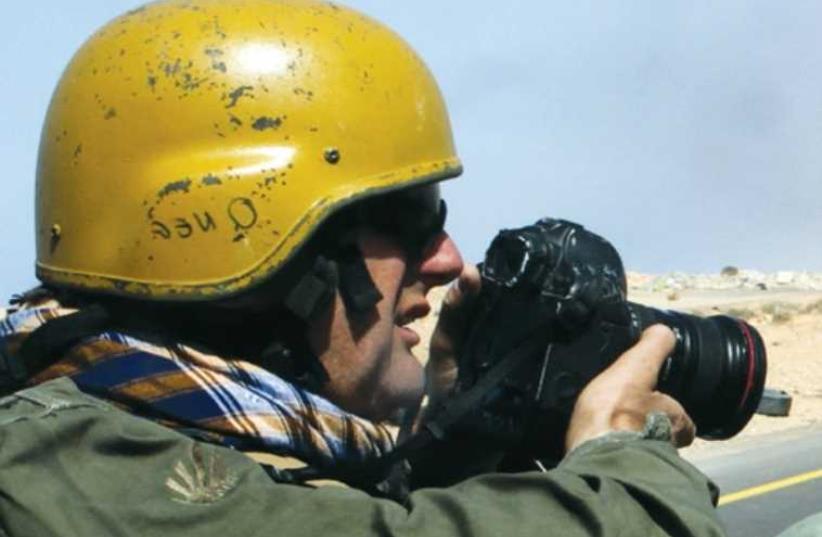 Photojournalist Goran Tomasevic working in the field in Libya, March 2011. (photo credit: REUTERS/HEIDI LEVINE)
