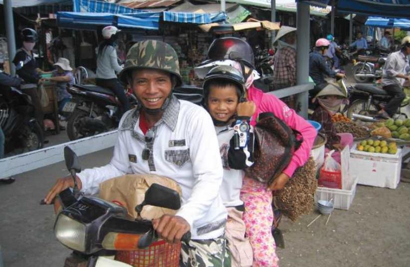 A VIETNAMESE family on a motorbike in Hanoi (photo credit: BEN G. FRANK)
