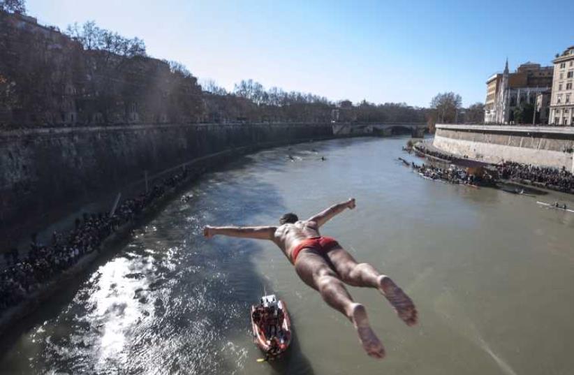 Walter Schirra of Italy, dives in the Tiber river as part of the traditional New Year celebrations on January 1, 2015 in Rome. (photo credit: AFP PHOTO / ANTONELLO NUSCA)