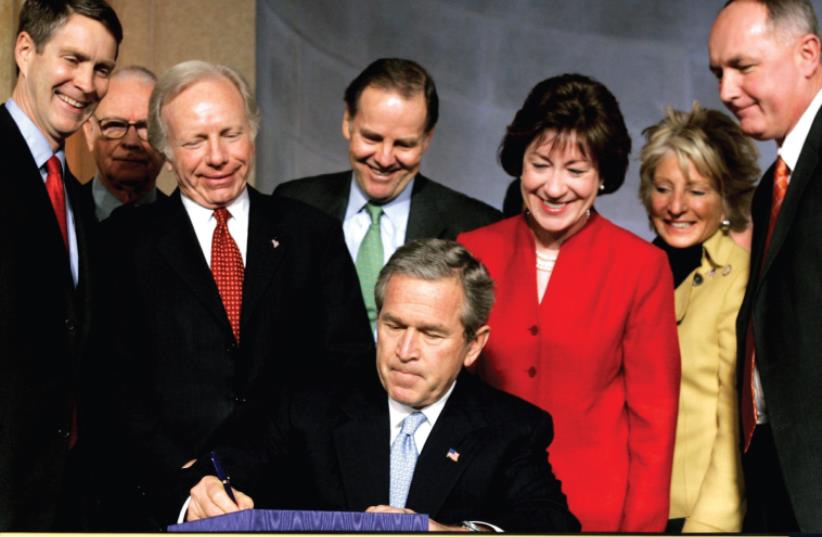 FORMER PRESIDENT George W. Bush signs the Intelligence Reform and Terrorism Prevention Act of 2004 in Washington (photo credit: KEVIN LAMARQUE/REUTERS)