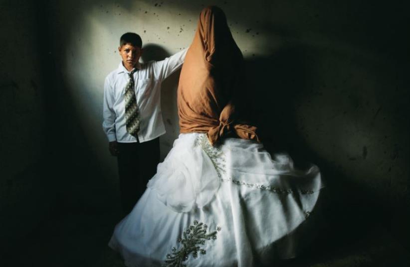 A 14-year-old Gazan poses with his new bride. (photo credit: ALI ALI)