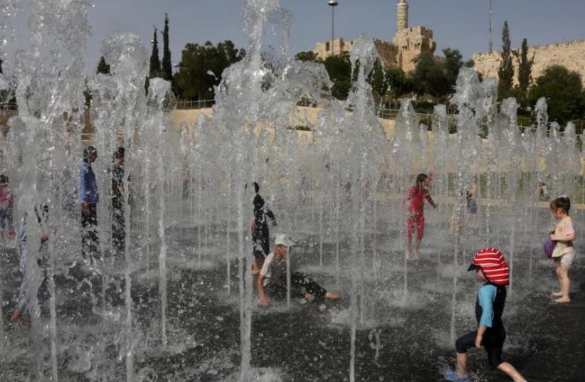Children play in Jerusalem fountain on extremely hot day, May 27, 2015 (photo credit: MARC ISRAEL SELLEM)
