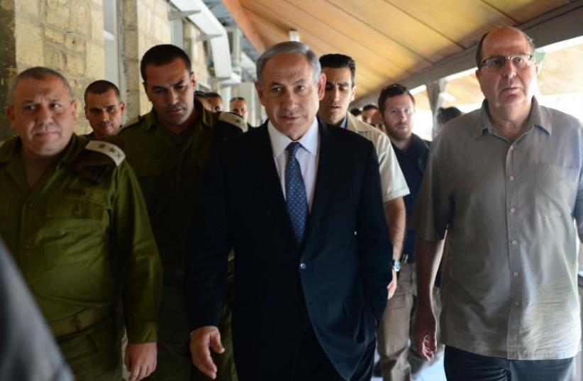 Prime Minister Benjamin Netanyahu (C) flanked by IDF Chief Lt.-Gen. Gadi Eisenkot (L) and Defense Minister Moshe Ya'alon (R) as he visits the Home Front Command for nationwide drill (photo credit: KOBI GIDEON/GPO)