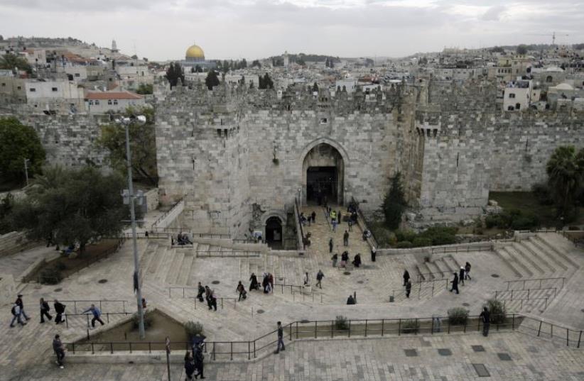 Passers-by walk near the Damascus Gate in Jerusalem's Old City [File[ (photo credit: REUTERS/AMMAR AWAD)