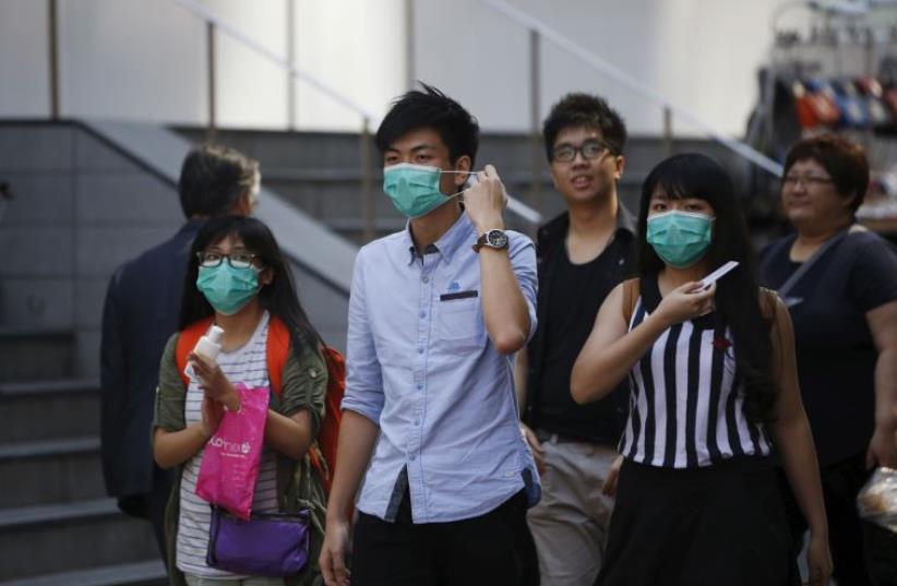 Tourists in Seoul, South Korea wear protective masks to prevent themselves from contracting Middle East Respiratory Syndrome (MERS) (photo credit: REUTERS)