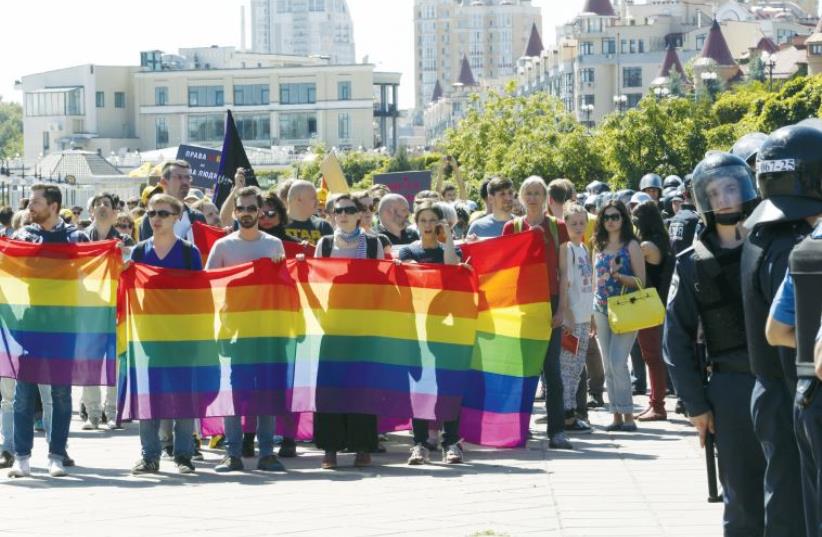 Ukrainian activists take part in an Equality March organized by the LGBT community, as Interior Ministry members stand guard. (photo credit: REUTERS)