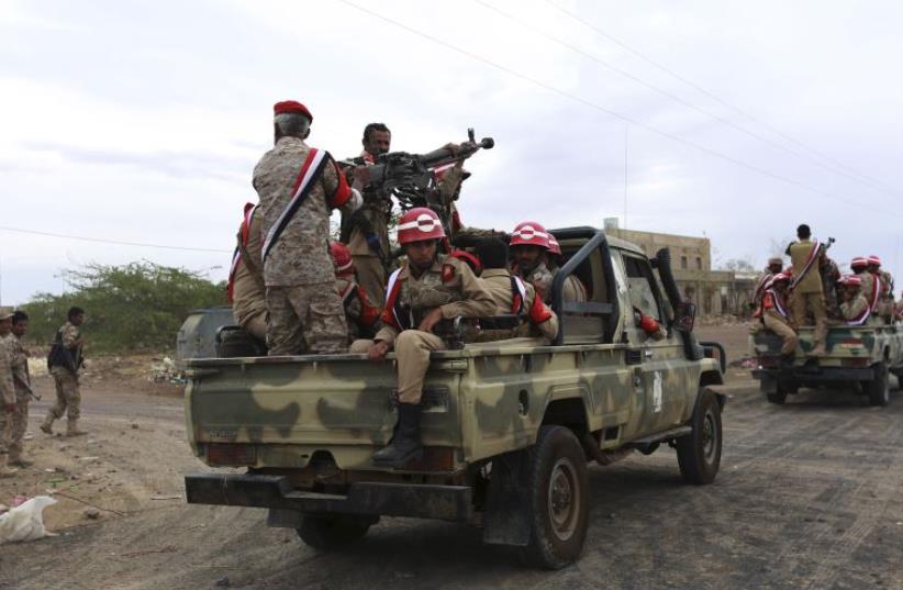 Soldiers loyal to Yemen's President Abd-Rabbu Mansour Hadi ride at the back of a pick-up truck during a parade in Yemen's northern province of Marib (photo credit: REUTERS)