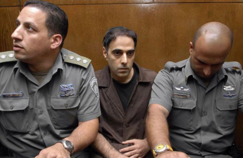 Israeli prison guards sit beside Yigal Amir (C), the assassin of Yitzhak Rabin, during a hearing in Tel Aviv district court, November 1, 2007 (photo credit: REUTERS)