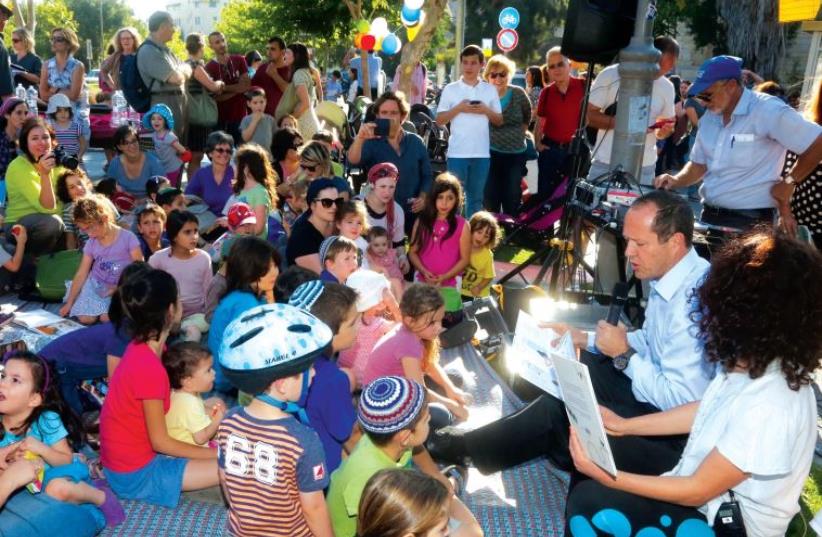 Jerusalem Mayor Nir Barkat helps kick off the opening by reading to a group of children in the park. (photo credit: MARC ISRAEL SELLEM/THE JERUSALEM POST)