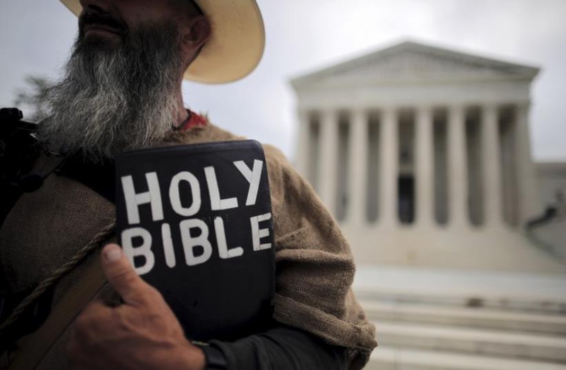 A protester holds a copy of the bible outside of the US Supreme Court building in Washington June 15, 2015. The US Supreme Court on Monday rejected a bid by the state of North Carolina to revive its law requiring women seeking an abortion to have an ultrasound of the fetus performed and described to (photo credit: REUTERS)