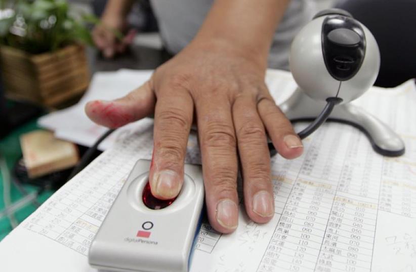 A man has his fingerprint scanned [file] (photo credit: REUTERS)