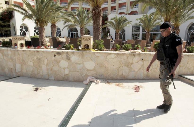  A police officer walks past blood at the Imperiale Marhaba hotel, Tunisia. (photo credit: REUTERS)