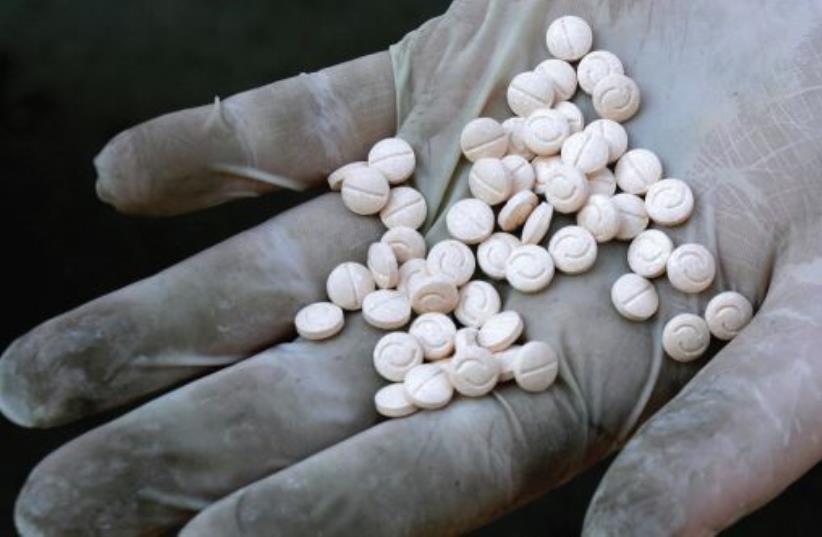 A customs officers displays confiscated Captagon pills (photo credit: REUTERS)