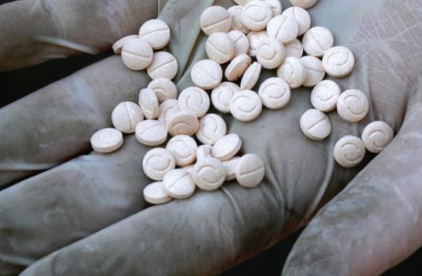 A customs officers displays confiscated Captagon pills (photo credit: REUTERS)
