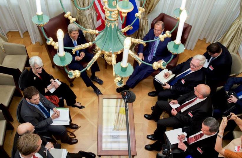 US Secretary of State John Kerry - seen through a hotel chandelier - and his advisers sit with Russian Foreign Minister Sergey Lavrov and their counterparts in Vienna (photo credit: STATE DEPARTMENT)