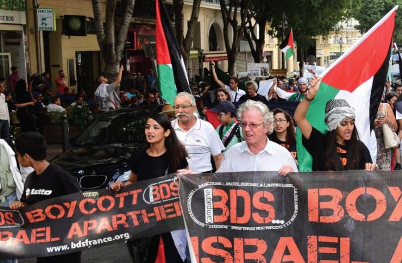 Anti-Israel demonstrators march behind a banner of the BDS organization in Marseille, June 13. (photo credit: GEORGES ROBERT / AFP)