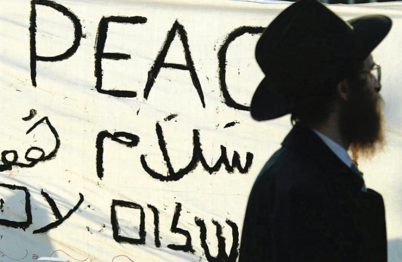 A jewish man passes a banner which reads ‘Peace Now’ during a pro-Israel demonstration held in Amsterdam several years ago. (photo credit: REUTERS)