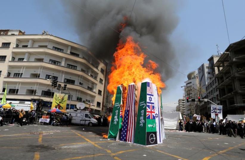 Iranian protesters burn Israeli, American and Saudi Arabian flags during a demonstration to mark the Quds (Jerusalem) International day in Tehran on July 10, 2015. (photo credit: AFP PHOTO)
