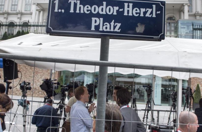 Journalists and television crews wait outside the Palais Coburg Hotel located at Theodor-Herzl square where the Iran nuclear talks meetings are being held in Vienna, Austria on July 13, 2015. (photo credit: JOE KLAMAR / AFP)