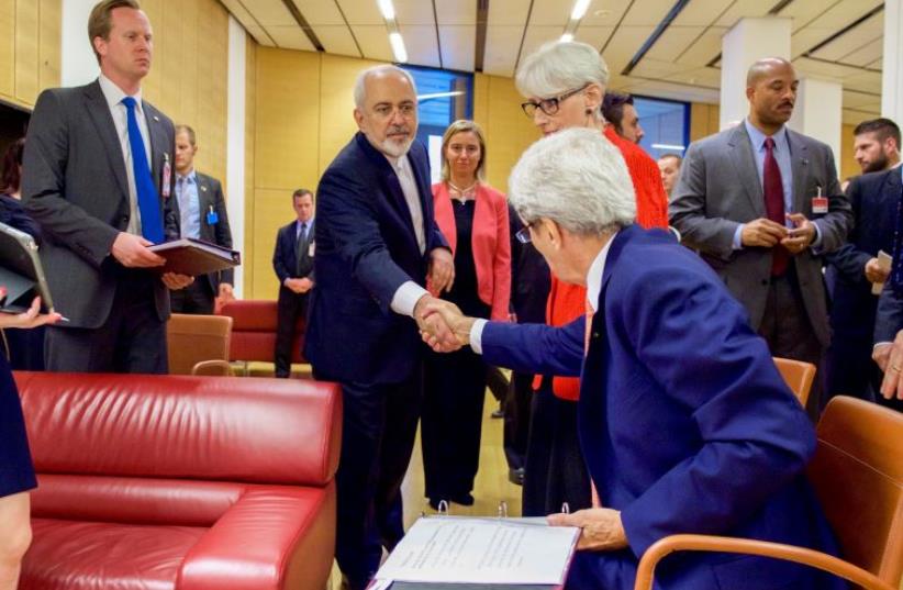 U.S. Secretary of State John Kerry shakes hands with Iranian Foreign Minister Javad Zarif as he prepares to leave the Austria Center in Vienna, Austria, on July 14, 2015, after the European Union, United States, and the rest of its P5+1 partners reached agreement on a plan to prevent Iran from obtai (photo credit: STATE DEPARTMENT PHOTO)
