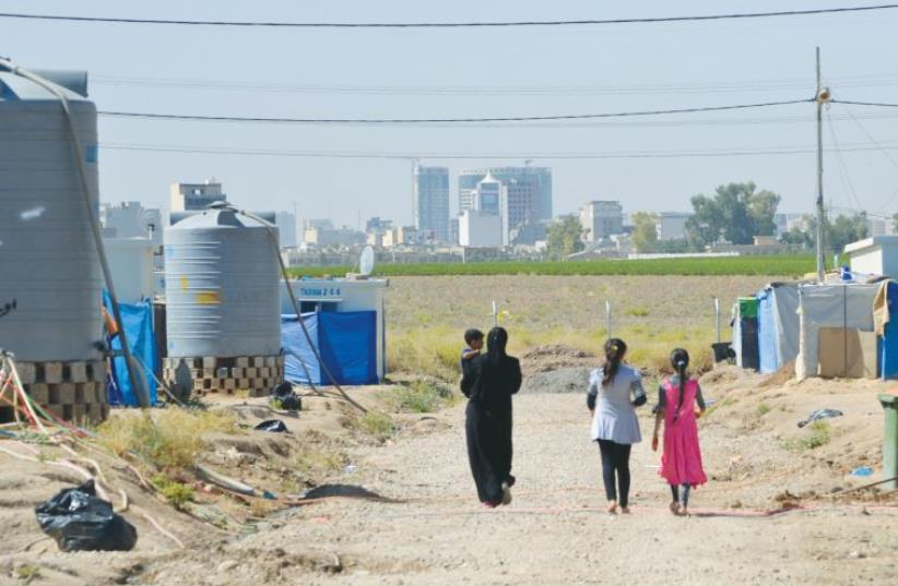 Internally displaced people walk in the Harsham Refugee camp, in Erbil. (photo credit: LAURA KELLY)